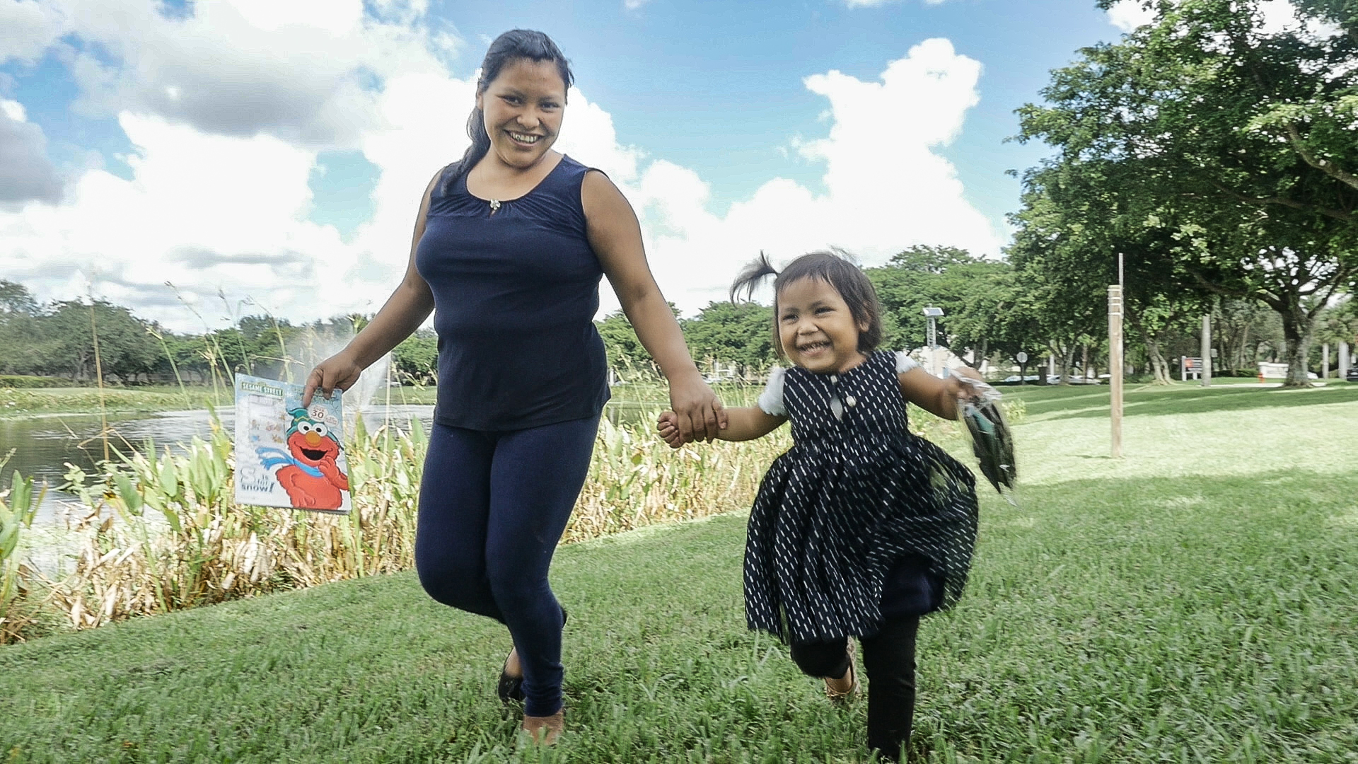 Mayra playing with her mother in front of a lake. 