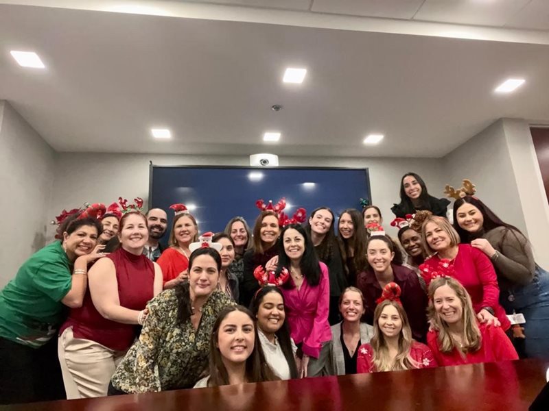 interns and faculty with heart shaped balloons inside conference room.