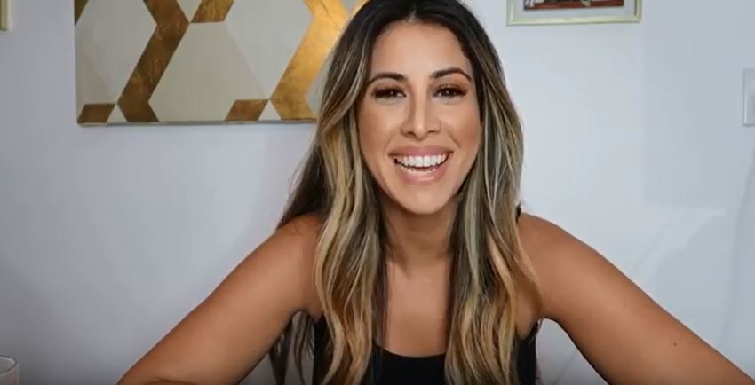 A smiling women sitting in a living room on a couch