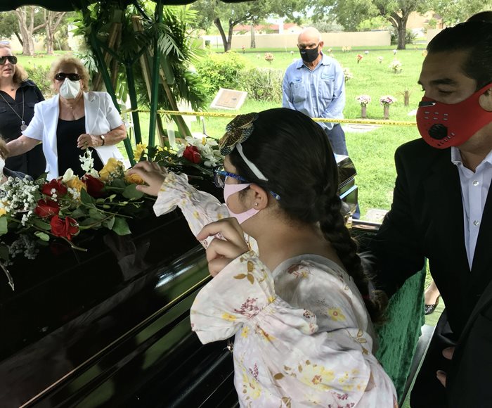 A young girl surrounded by family attending a funeral service