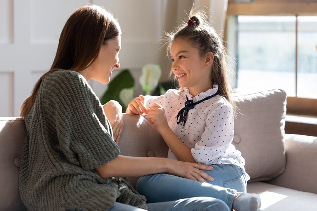 Mom talking to daughter on the couch