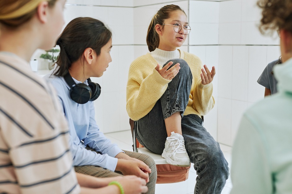 Teen girl talking to a group of teens