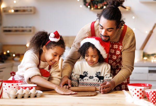 Padre haciendo galletas navideñas con su hijo e hija