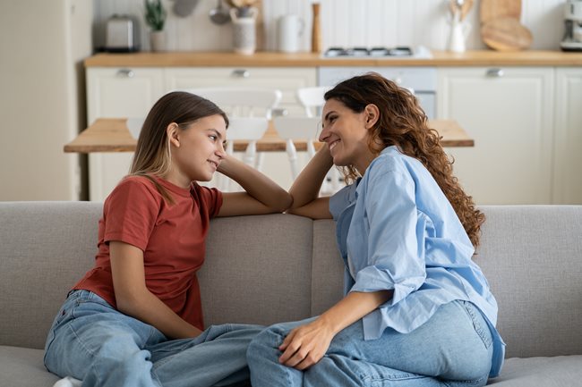 Mother and daughter talking on the couch