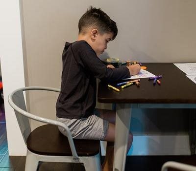 A little boy at a table coloring 