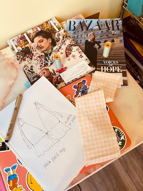 A table of fashion magazines and fabric