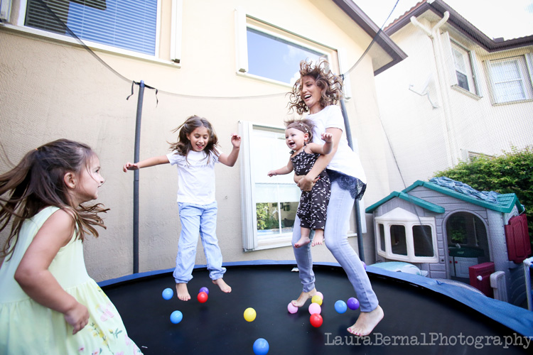 una madre y tres hijas saltando en un trampolín