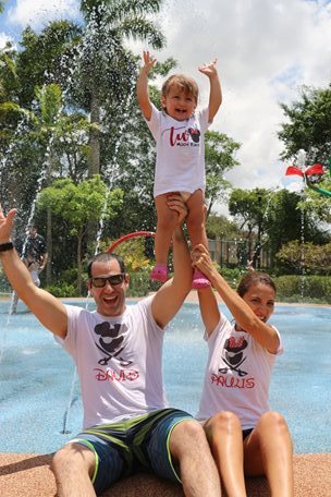 un padre y una madre levantando a su hijo