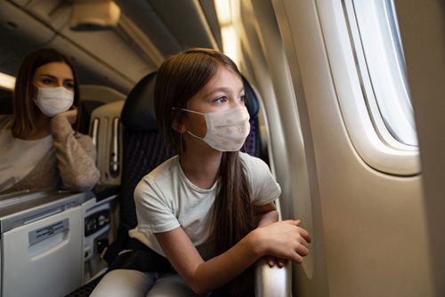 Girl on a plane wearing a mask