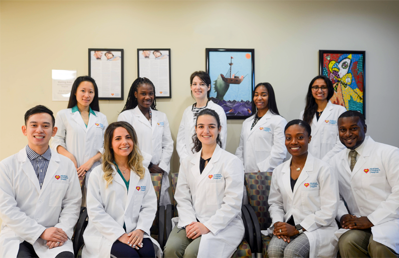 dental residents smiling in their crisp white lab coats.