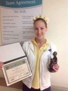 awardee wearing a headband of daisies, daisy award statue, and certificate.