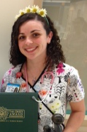 awardee wearing a headband of daisies, daisy award statue, and certificate.