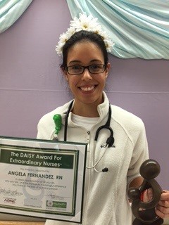 awardee wearing a headband of daisies, daisy award statue, and certificate.