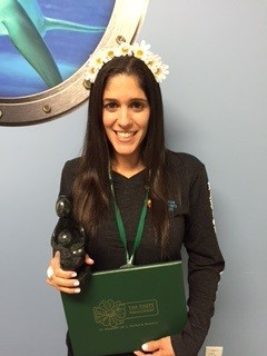 awardee wearing a headband of daisies, daisy award statue, and certificate.