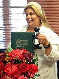 awardee wearing a headband of daisies, daisy award statue, and certificate.