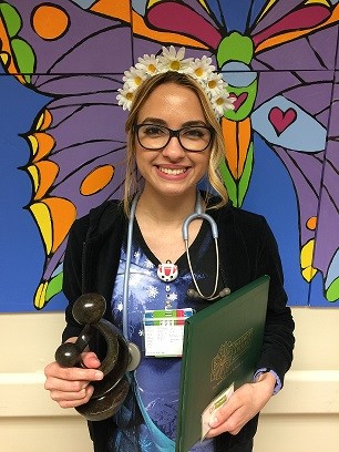 awardee wearing a headband of daisies, daisy award statue, and certificate.