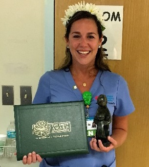 awardee wearing a headband of daisies, daisy award statue, and certificate.