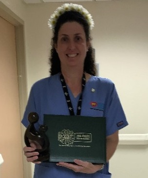 awardee wearing a headband of daisies, daisy award statue, and certificate.