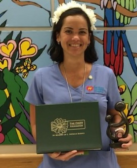 awardee wearing a headband of daisies, daisy award statue, and certificate.