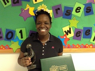 awardee wearing a headband of daisies, daisy award statue, and certificate.