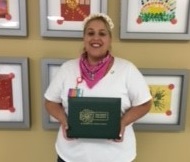 awardee wearing a headband of daisies, daisy award statue, and certificate.