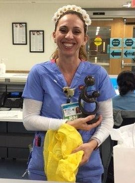 awardee wearing a headband of daisies, daisy award statue, and certificate.