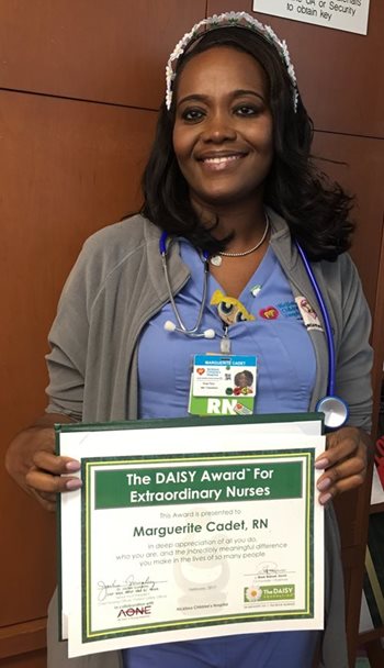 awardee wearing a headband of daisies, daisy award statue, and certificate.