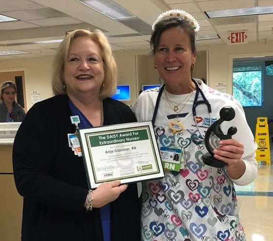 awardee wearing a headband of daisies, daisy award statue, and certificate.