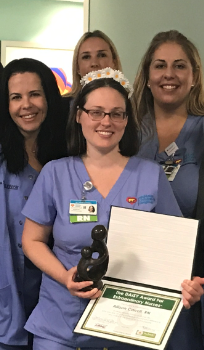 awardee wearing a headband of daisies, daisy award statue, and certificate.