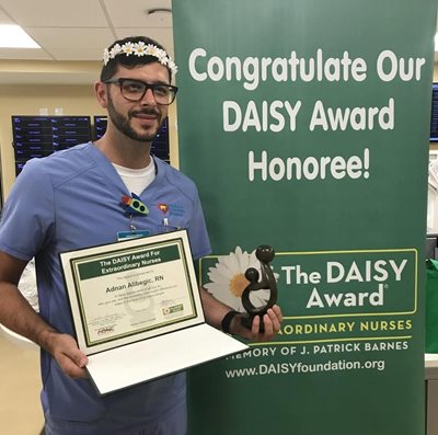 awardee wearing a headband of daisies, daisy award statue, and certificate.