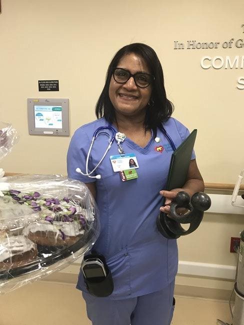 awardee wearing a headband of daisies, daisy award statue, and certificate.