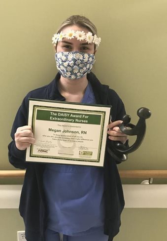 awardee wearing a headband of daisies, daisy award statue, and certificate.