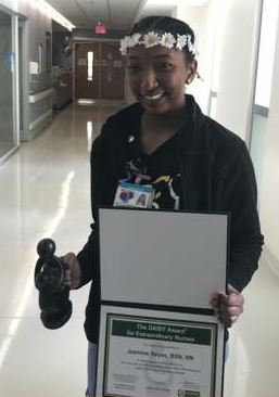 awardee wearing a headband of daisies, daisy award statue, and certificate.