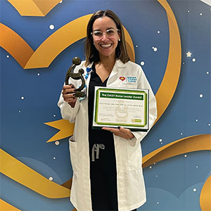 awardee wearing a headband of daisies, daisy award statue, and certificate.