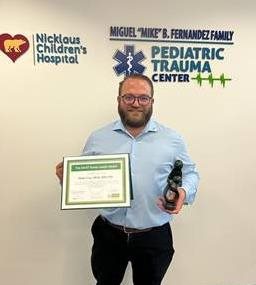 awardee wearing a headband of daisies, daisy award statue, and certificate.