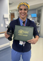awardee wearing a headband of daisies, daisy award statue, and certificate.
