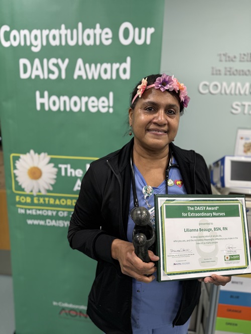 awardee wearing a headband of daisies, daisy award statue, and certificate.