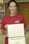 awardee wearing a headband of daisies, daisy award statue, and certificate.