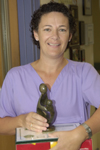 awardee wearing a headband of daisies, daisy award statue, and certificate.