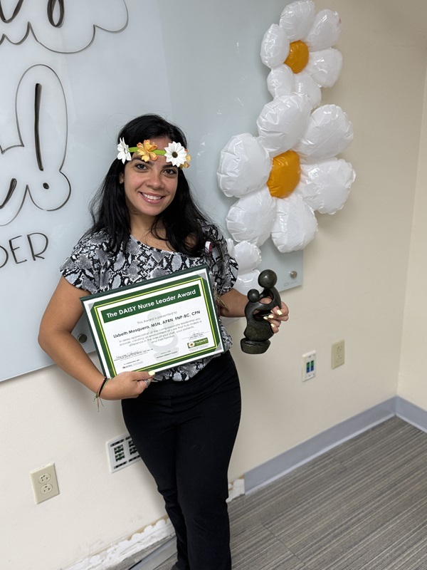 awardee wearing a headband of daisies, daisy award statue, and certificate.