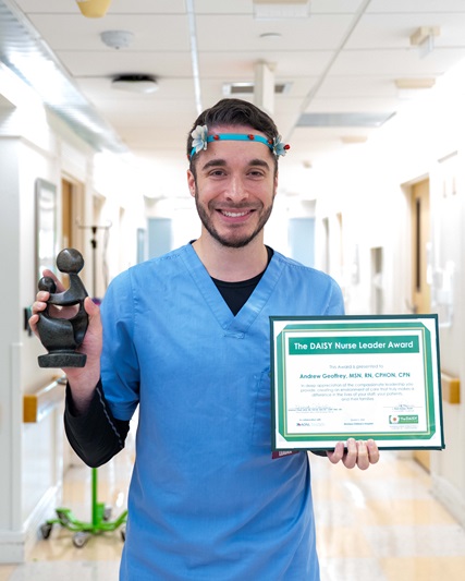 awardee wearing a headband of daisies, daisy award statue, and certificate.