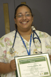 awardee wearing a headband of daisies, daisy award statue, and certificate.