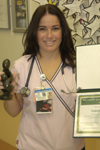 awardee wearing a headband of daisies, daisy award statue, and certificate.