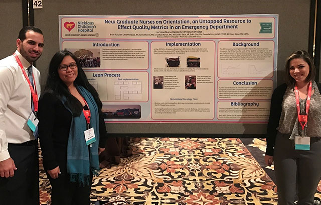 3 nurses standing next to presentation poster