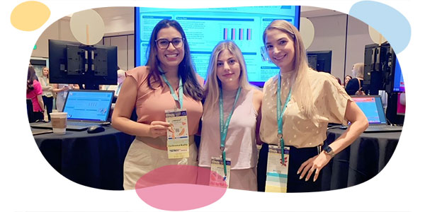 three blonde nurses smile as they attend a conference.