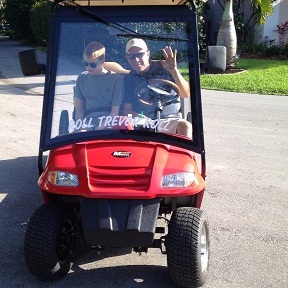 Tevor riding in a golf cart. 