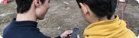 Two young boys using a cell phone
