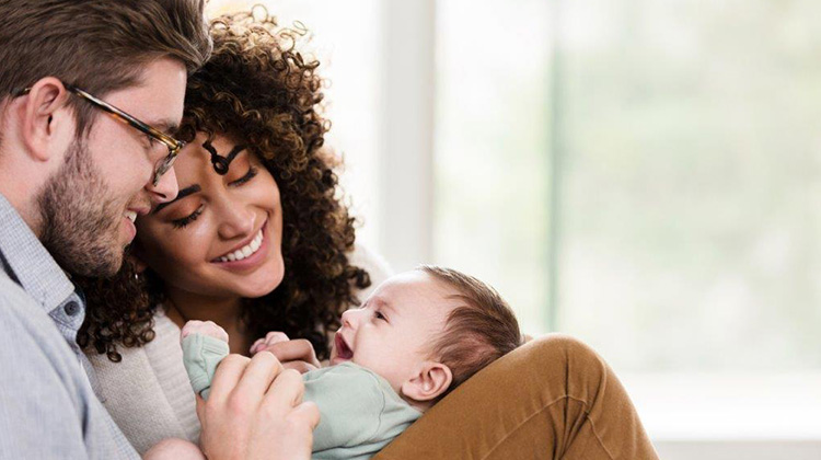 young interracial parents cooing over their baby