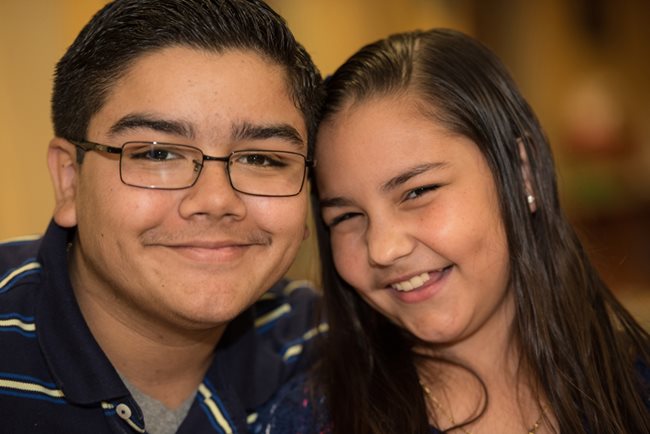 primer plano de hermano y hermana sonriendo.