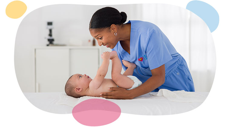 enfermera mimando a un bebé durante un examen.